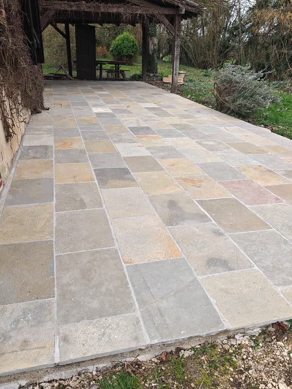 Terrasse sous préau en pierre multicolore